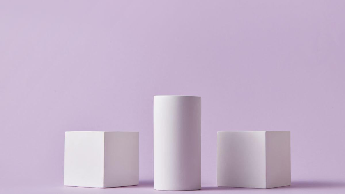White geometric shapes standing on a lilac background.