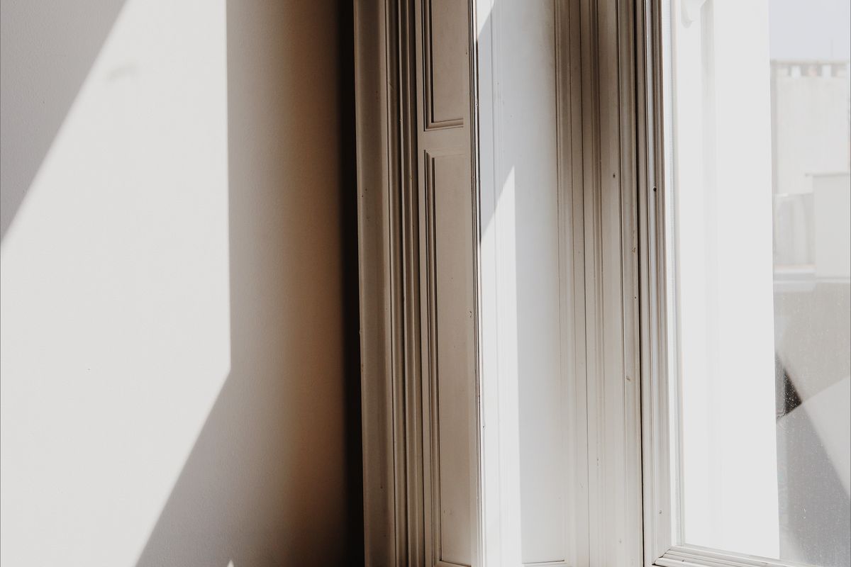 Soft daylight falling through a white-framed window onto a pale curtain.